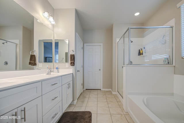 bathroom featuring a stall shower, double vanity, a sink, and tile patterned flooring