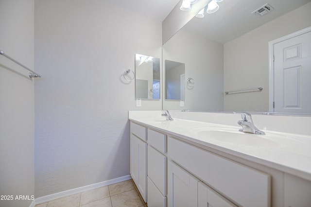 bathroom featuring a sink, visible vents, baseboards, and double vanity