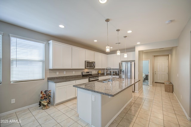 kitchen with light tile patterned floors, a sink, white cabinets, and stainless steel appliances