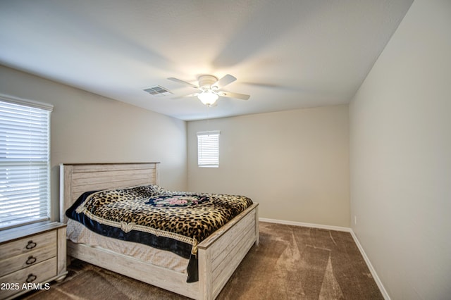 bedroom with dark carpet, visible vents, baseboards, and a ceiling fan