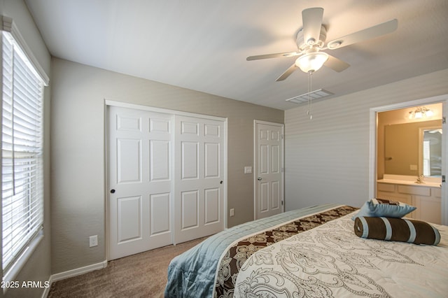 carpeted bedroom featuring visible vents, a ceiling fan, a closet, and ensuite bath