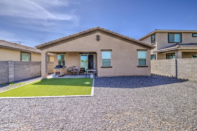 rear view of property featuring a patio area, a yard, a fenced backyard, and stucco siding