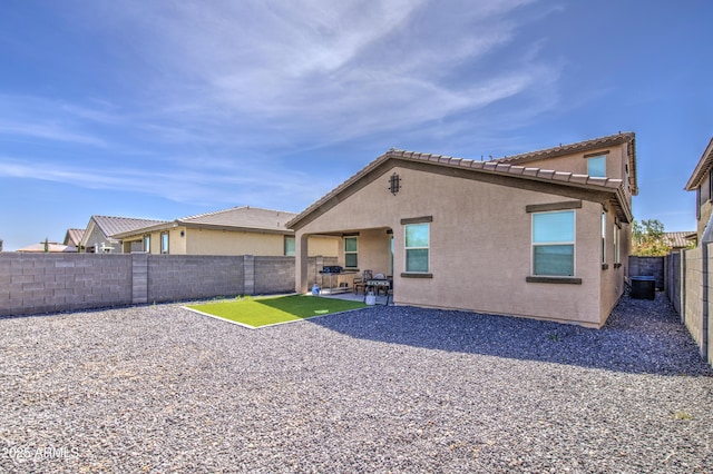 rear view of house with cooling unit, a patio, a fenced backyard, and stucco siding