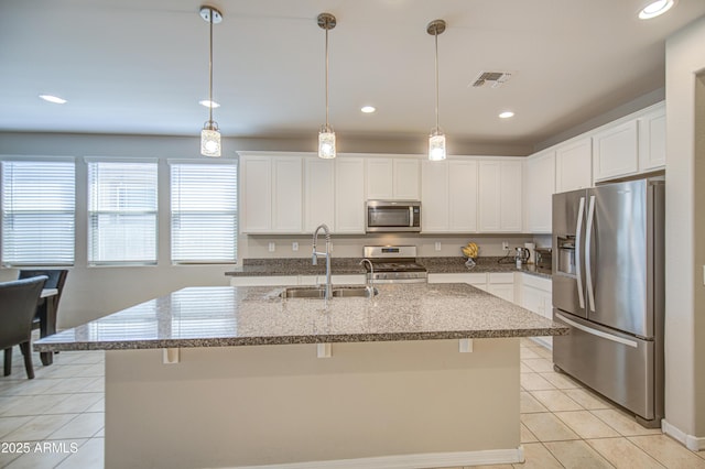 kitchen with light tile patterned flooring, visible vents, a center island with sink, appliances with stainless steel finishes, and a sink