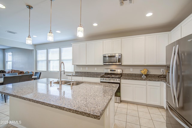 kitchen with stainless steel appliances, light tile patterned floors, visible vents, and a sink