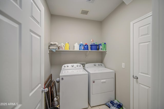 laundry room with visible vents, washing machine and dryer, laundry area, and light tile patterned floors