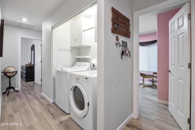 laundry area with cabinets, separate washer and dryer, and light hardwood / wood-style flooring