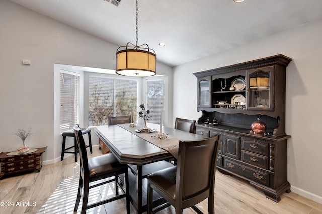 dining room with light hardwood / wood-style floors and vaulted ceiling