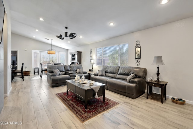 living room with light hardwood / wood-style flooring, vaulted ceiling, and ceiling fan