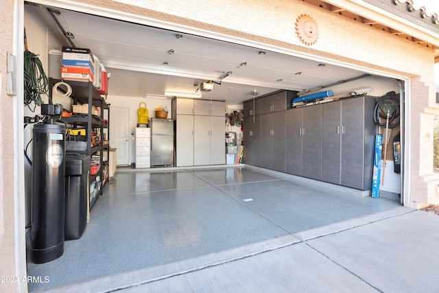 garage featuring a garage door opener and stainless steel refrigerator