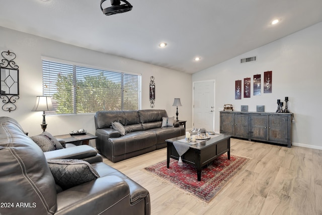 living room with light hardwood / wood-style floors and lofted ceiling