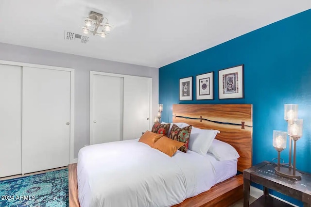 bedroom with two closets and hardwood / wood-style floors