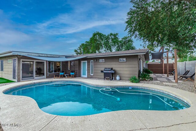 view of swimming pool with a patio area and a grill