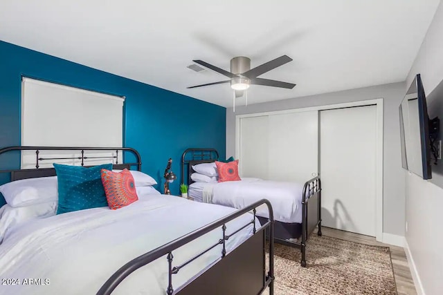 bedroom with a closet, light wood-type flooring, and ceiling fan