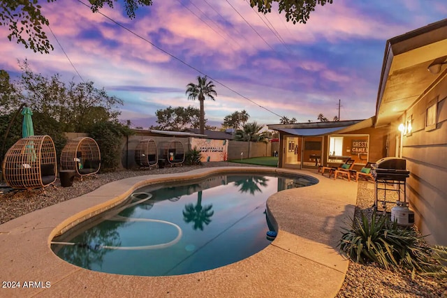 pool at dusk with a patio