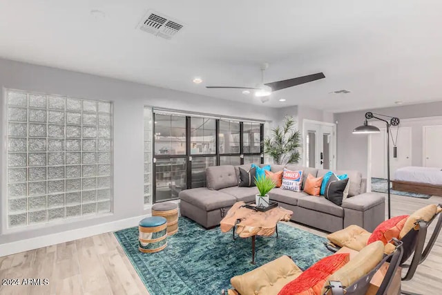 living room with light hardwood / wood-style floors and ceiling fan