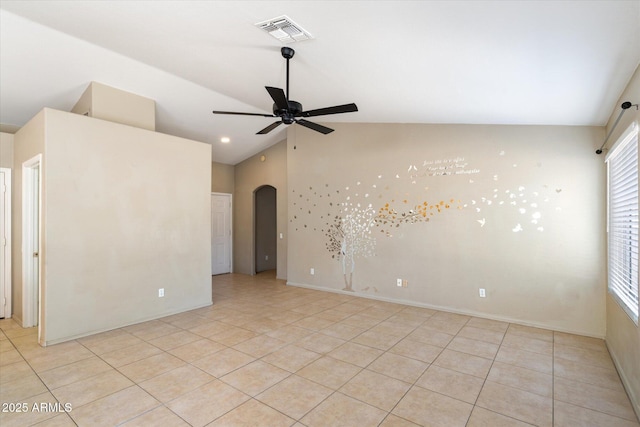 spare room featuring arched walkways, light tile patterned floors, visible vents, a ceiling fan, and vaulted ceiling