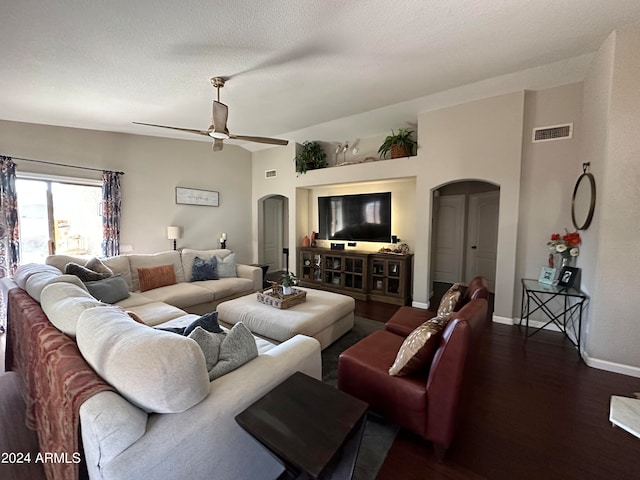 living room featuring a textured ceiling, dark wood-type flooring, and ceiling fan