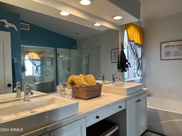 bathroom featuring vaulted ceiling, vanity, and separate shower and tub