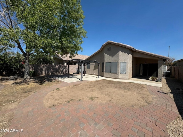 rear view of property with a pergola and a patio area