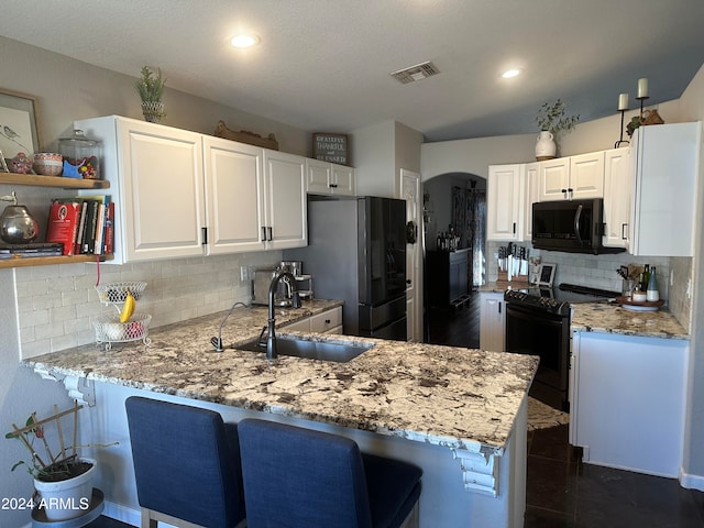 kitchen featuring black appliances, kitchen peninsula, sink, and white cabinets