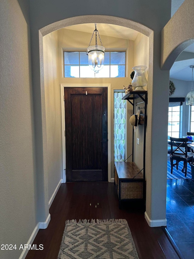 entrance foyer featuring an inviting chandelier and dark wood-type flooring