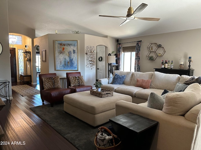 living room featuring ceiling fan and dark wood-type flooring