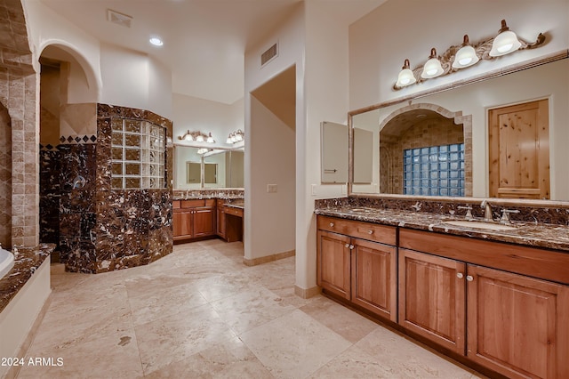 bathroom featuring vanity and independent shower and bath