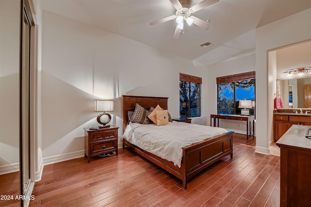 bedroom featuring ceiling fan, sink, light hardwood / wood-style flooring, and ensuite bathroom