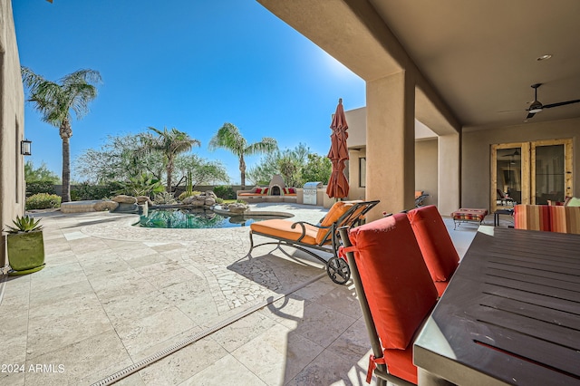 view of patio / terrace with ceiling fan and a pool with hot tub