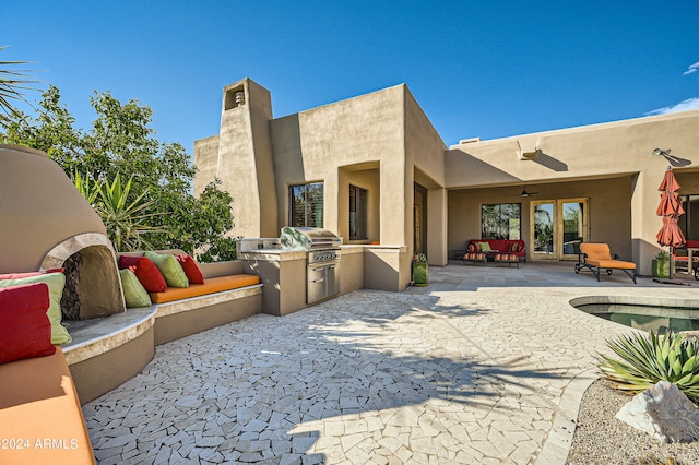 view of patio / terrace with an outdoor kitchen, ceiling fan, and grilling area