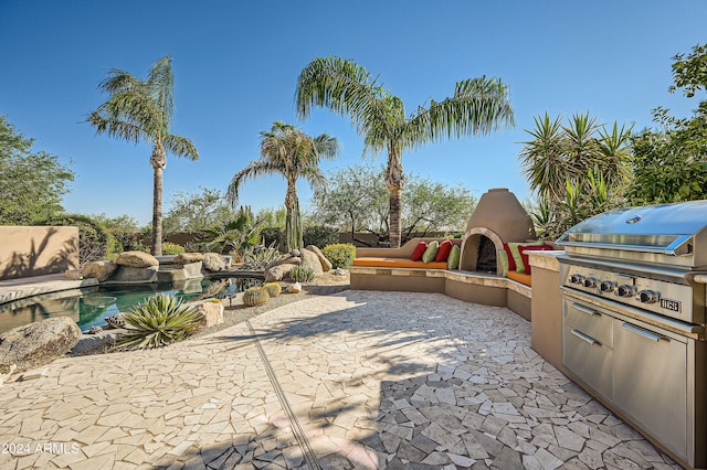 view of patio / terrace with exterior kitchen and a grill