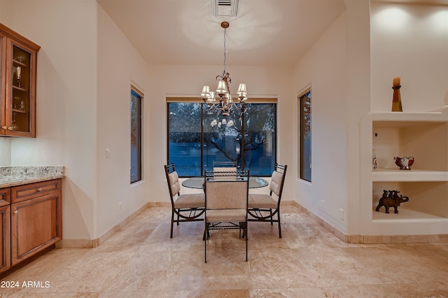 dining room with built in features and a chandelier