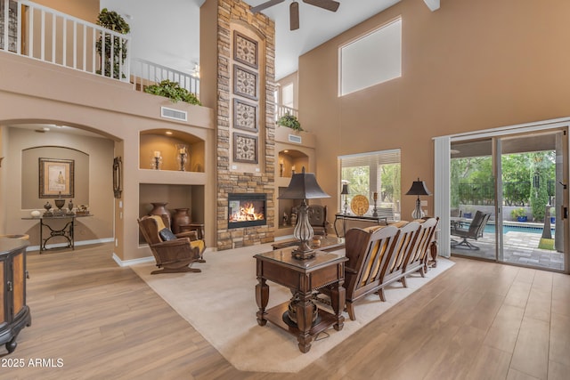 9702 E Naranja Ave, Mesa, AZ 85209 - living area with ceiling fan, arched walkways, wood finished floors, a fireplace, and a high ceiling