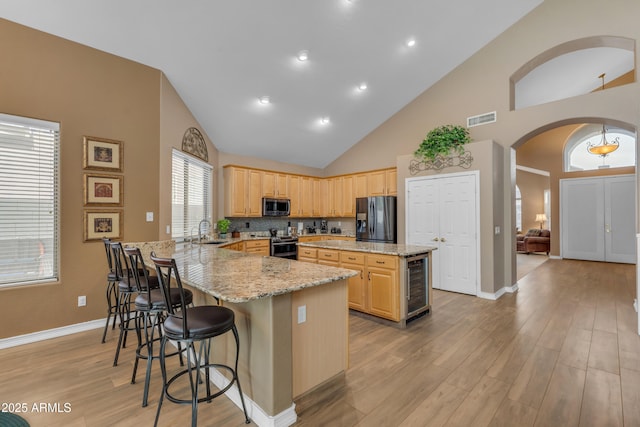 9702 E Naranja Ave, Mesa, AZ 85209 - kitchen with stainless steel appliances, arched walkways, beverage cooler, a sink, and a peninsula