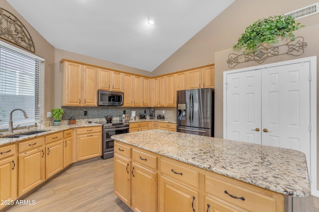 9702 E Naranja Ave, Mesa, AZ 85209 - kitchen featuring stainless steel appliances, light brown cabinetry, a sink, light wood-style flooring, and decorative backsplash