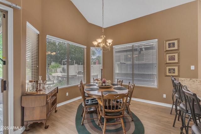 9702 E Naranja Ave, Mesa, AZ 85209 - dining area featuring a chandelier, light wood-style floors, baseboards, and high vaulted ceiling