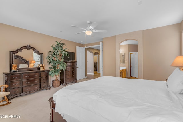 9702 E Naranja Ave, Mesa, AZ 85209 - bedroom with arched walkways, light colored carpet, ceiling fan, and connected bathroom