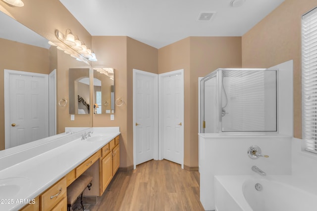 9702 E Naranja Ave, Mesa, AZ 85209 - bathroom featuring double vanity, a bath, wood finished floors, a stall shower, and baseboards
