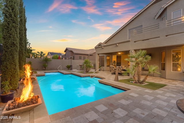 9702 E Naranja Ave, Mesa, AZ 85209 - pool at dusk with an outdoor fire pit, a patio, and a fenced backyard