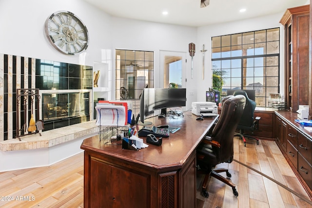 office featuring a fireplace and light hardwood / wood-style flooring