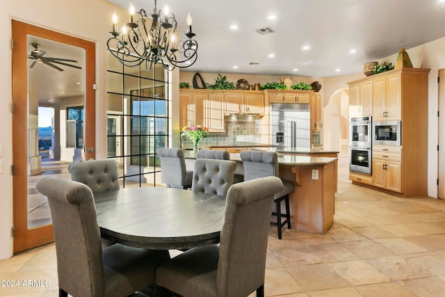 dining space with ceiling fan with notable chandelier