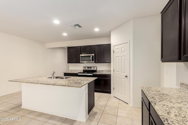 24627 W Ripple Rd, Buckeye, AZ 85326 - kitchen featuring stainless steel microwave, range with electric stovetop, light tile patterned floors, light stone countertops, and recessed lighting