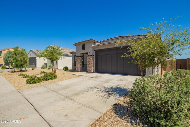 24627 W Ripple Rd, Buckeye, AZ 85326 - view of front of home with stucco siding, a garage, driveway, a tiled roof, and stone siding
