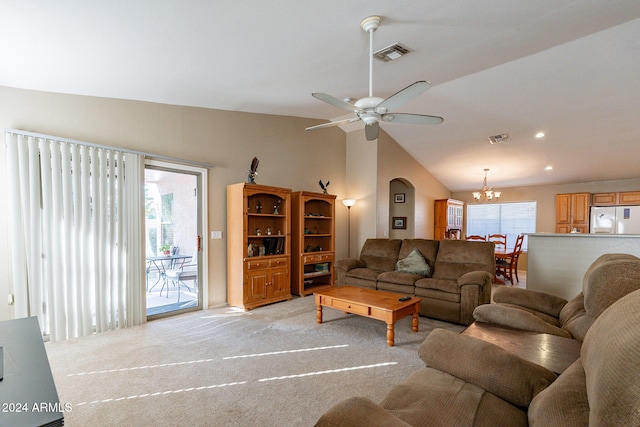 living room featuring vaulted ceiling, light colored carpet, a healthy amount of sunlight, and ceiling fan with notable chandelier