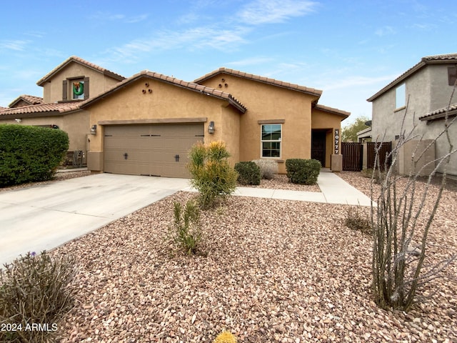 view of front of home featuring driveway, a garage, fence, and stucco siding