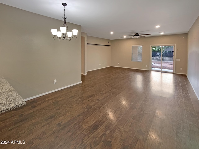 spare room featuring dark wood-style floors, recessed lighting, baseboards, and ceiling fan with notable chandelier