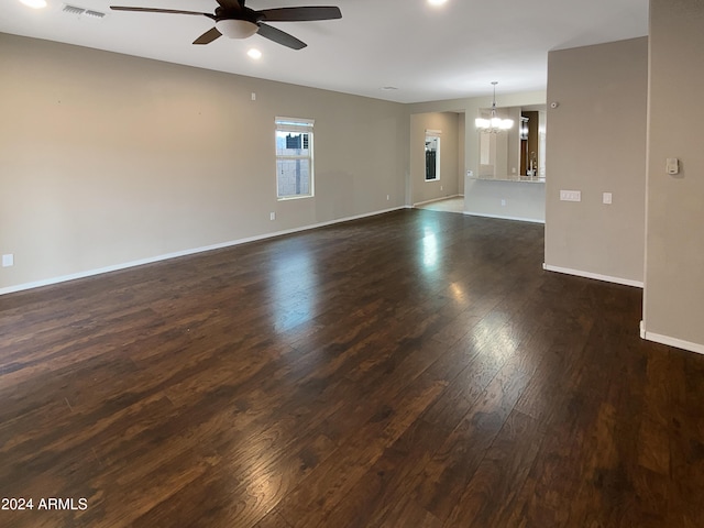 unfurnished room with dark wood-style floors, recessed lighting, visible vents, baseboards, and ceiling fan with notable chandelier