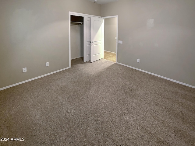 unfurnished bedroom with carpet floors, a closet, and baseboards