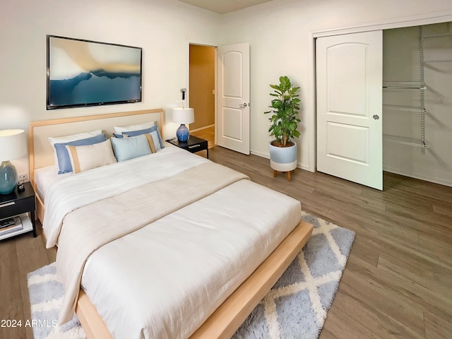 bedroom featuring a closet, wood finished floors, and baseboards